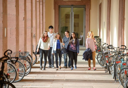 Eine Gruppe von Studierenden läuft durch einen Gang auf dem Ehrenhof