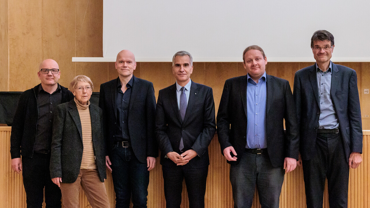 Welttag der Philosophie 2024: Gruppenfoto Gruppenfoto zum Tag der Philosophie am 21.11.2024. Von links nach rechts stehen nebeneinander: Prof. Dr. Wolfgang Freitag, Prof. Dr. Dr. h. c. Ursula Wolf, Prof. Dr. Dietmar Heidemann, Prof. Dr. Thomas Fetzer, Prof. Dr. Andreas Cassee, Prof. Dr. Bernward Gesang. Im Hintergrund holzvertäfelte Bühne bei herabgelassener Leinwand der Aula der Universität Mannheim.