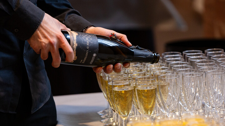 Sektgläser werden mit Sekt gefüllt.