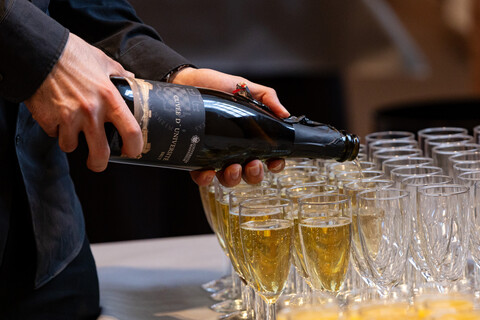 Sektgläser werden mit Sekt gefüllt.