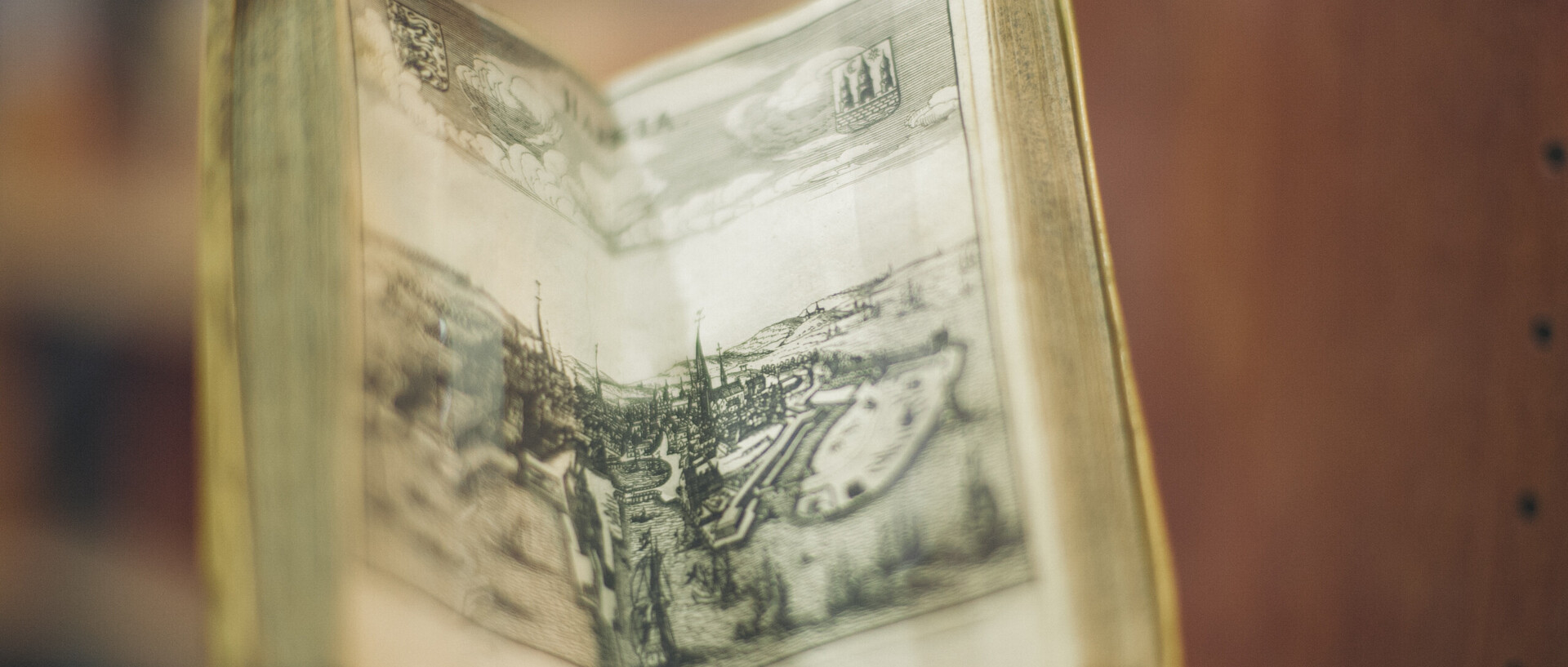 geöffnetes halb stehendes altes Buch mit Stadtansicht