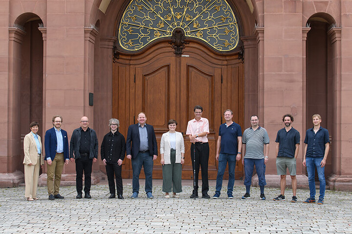 Das Team des Philosophischen Seminars stehen vor dem Eingang zum Mannheimer Rittersaal.