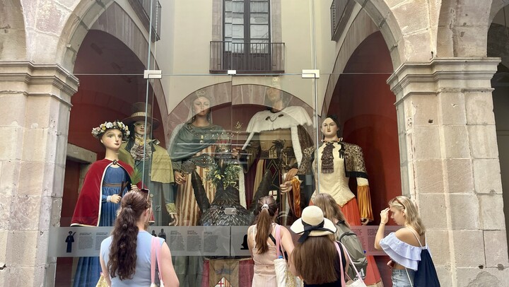 Studierende stehen vor einem Schaufenster und bestaunen traditionelle katalanische Trachten