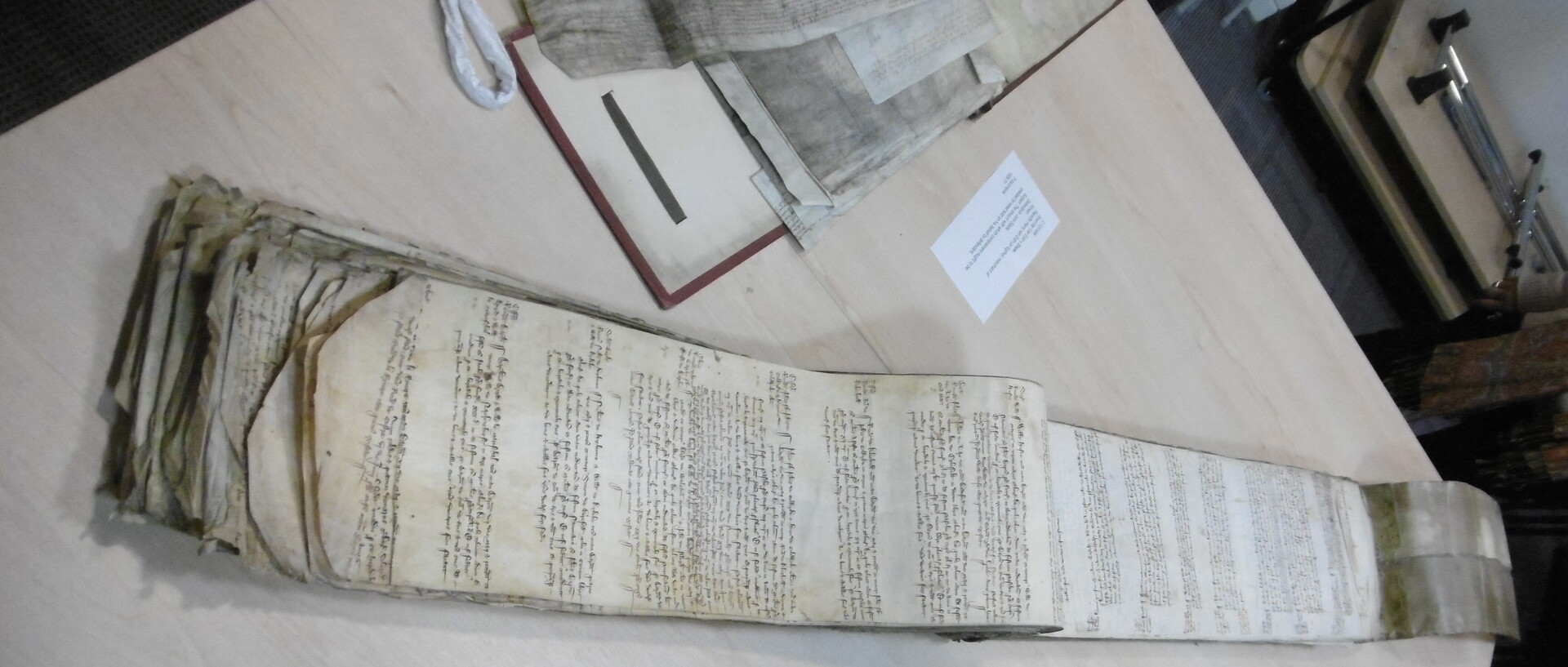 Abbildung eines Manuskriptes, das auf einem Tisch ausgebreitet liegt.