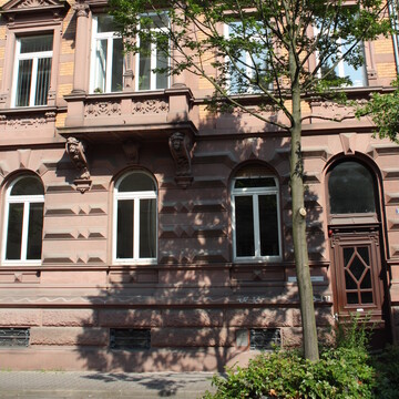 Dreistöckiges Haus mit Baum davor