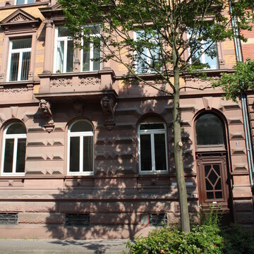 Dreistöckiges Haus mit Baum davor