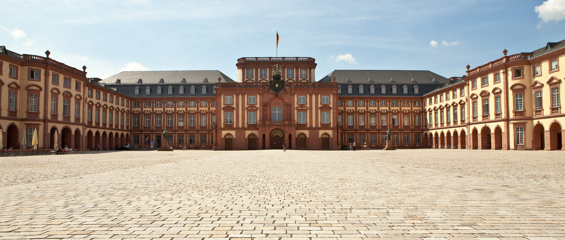 Das Mannheimer Barockschloss und der Ehrenhof unter blauem Himmel.