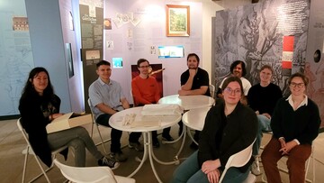 Eine Gruppe von 8 Personen sitzt an einem Tisch.