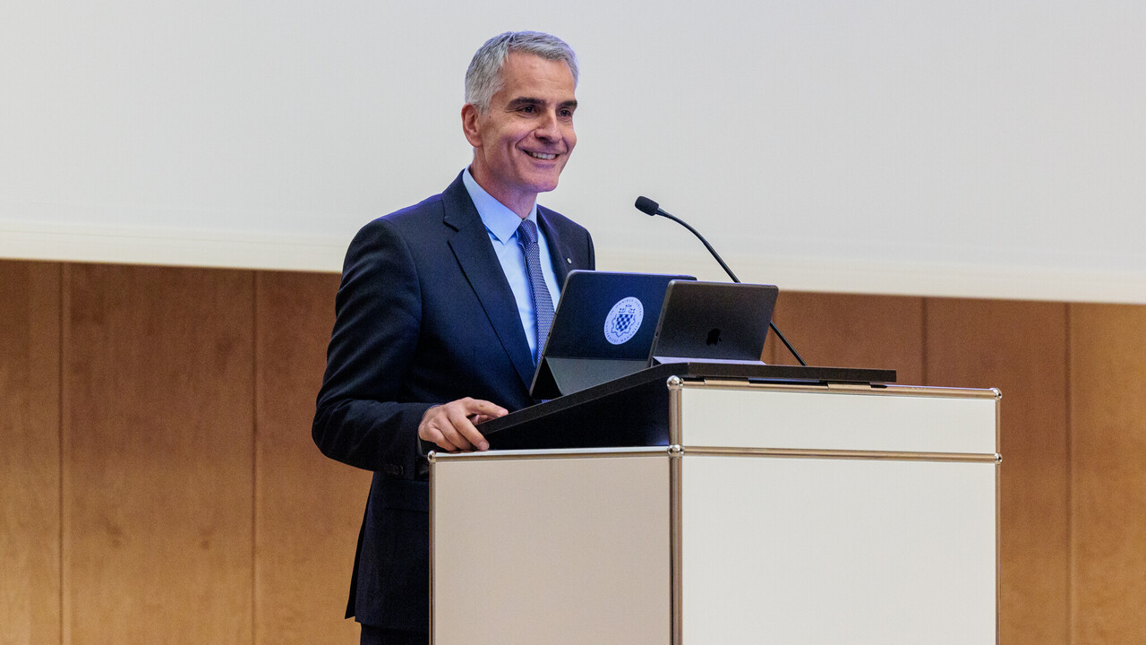 Grußwort von Rektor Prof. Dr. Thomas Fetzer Prof. Dr. Thomas Fetzer am Rednerpult beim Grußwort zum Tag der Philosophie am 21.11.2024. Er trägt eine dunkle Anzugjacke auf hellblauem Hemd mit dunkelblauer Krawatte.