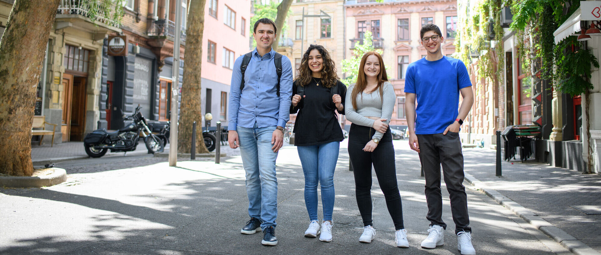 Vier lachende Studierende auf einer verkehrsberuhigten Straße im Mannheimer Jungbusch