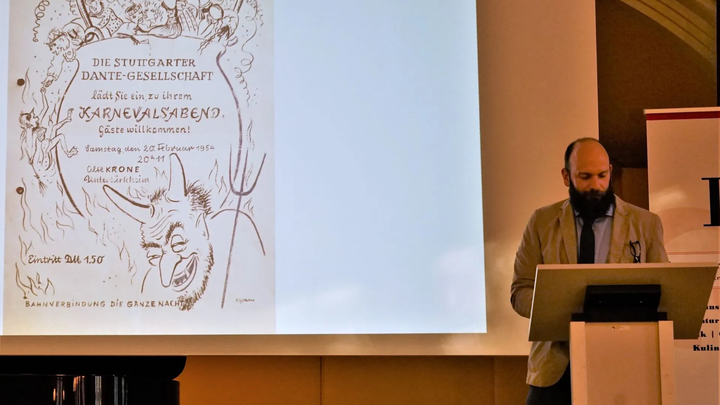 Ein Mann steht auf einem Podium, neben ihm eine Leinwand.