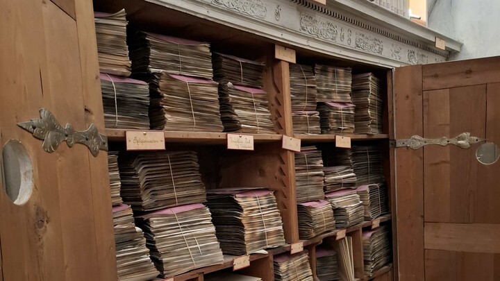 Ein geöffneter Schrank, darin alte Aktenbündel