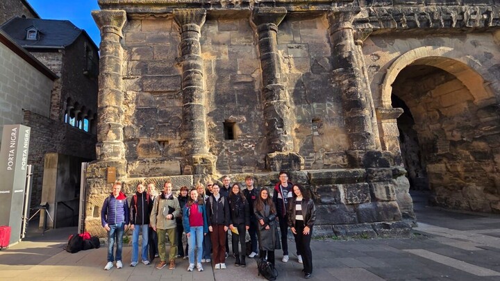 Die Teilnehmenden der Exkursion stehen vor der Porta Nigra in Trier. 
