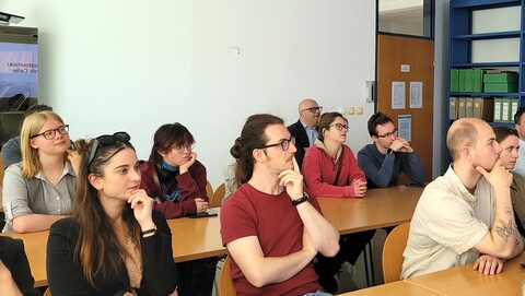 Die Teilnehmenden der Summer School sitzen in einem modernen Archivraum und hören aufmerksam zu.