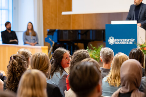 Der Dekan steht am Rednerpult und begrüßt die Gäste in der Aula.