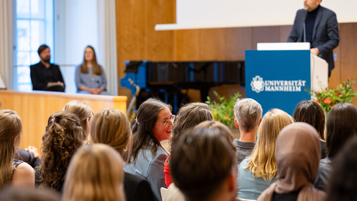 Der Dekan steht am Rednerpult und begrüßt die Gäste in der Aula.