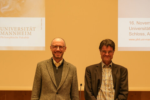 Prof. Dr. Gerhard Ernst und Prof. Dr. Bernward Gesang auf der Bühne vor dem Rednerpult