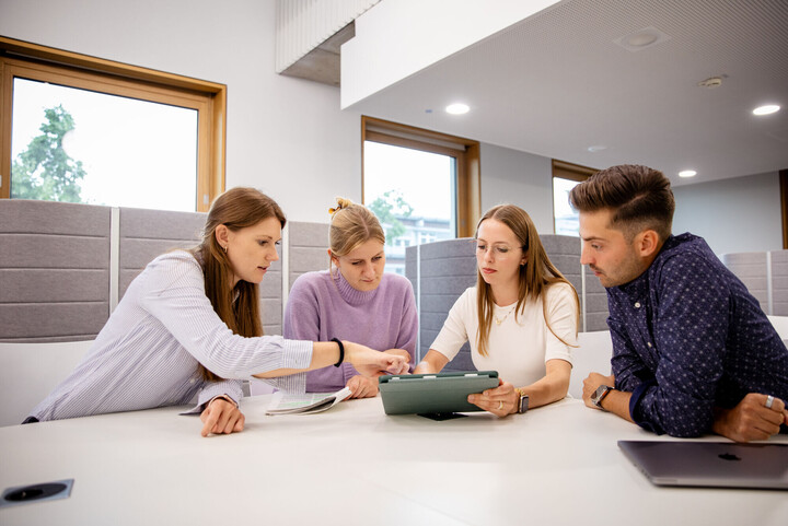 Gruppe von vier Forschenden im Gebäude B6 der Universität