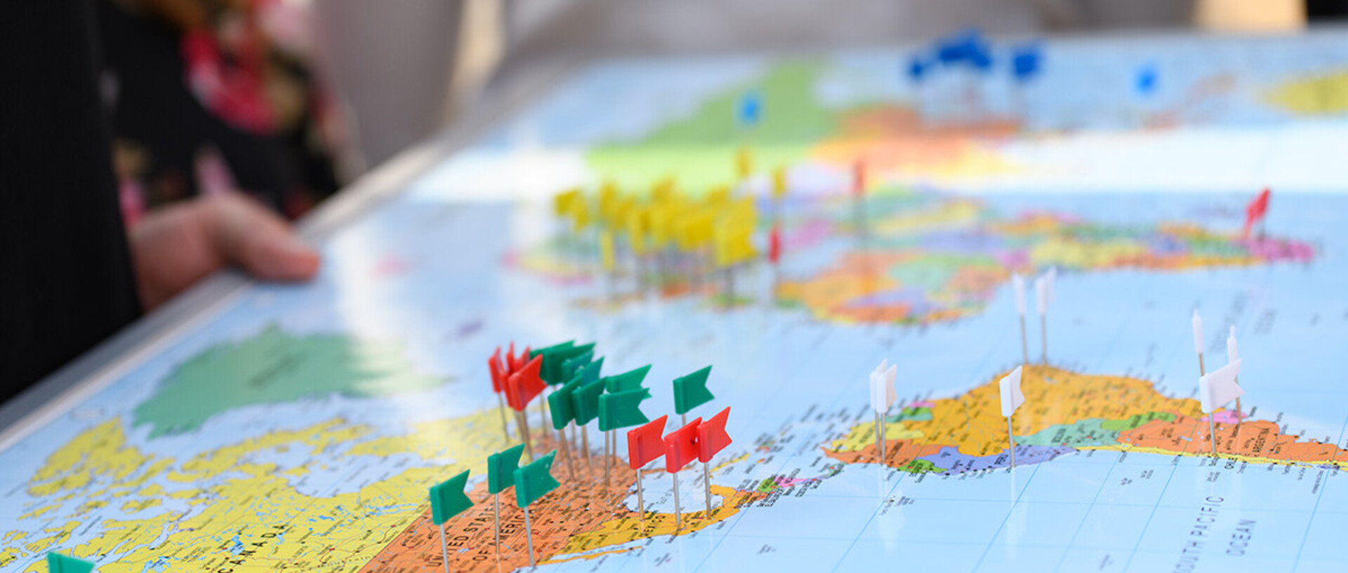 Several colorful pins are stuck into a map of the world.