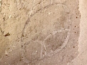 Eine in eine steinerne Außenmaußer eingeritzte Bretzelform.