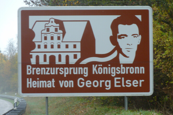 Straßenschild mit der Aufschrift "Brenzursprung Königsbronn. Heimat von Georg Elser". 