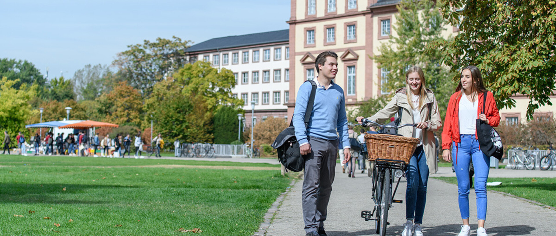 Drei Studierende laufen über die Mensawiese.