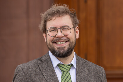 Brustbild eines Mannes mit Bart, Brille und Krawatte