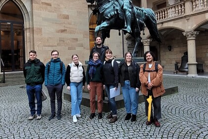 8 Personen vor einer Statue im Innenhof eines Schlosses