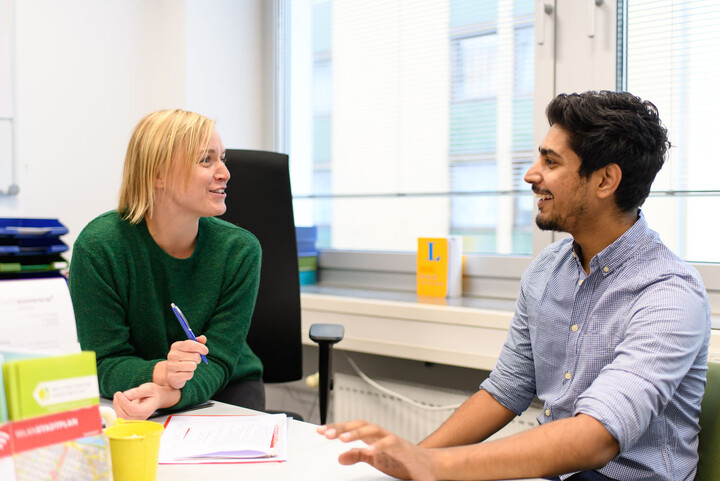 Eine Mitarbeiterin des Akademischen Auslandsamtes berät einen Studenten