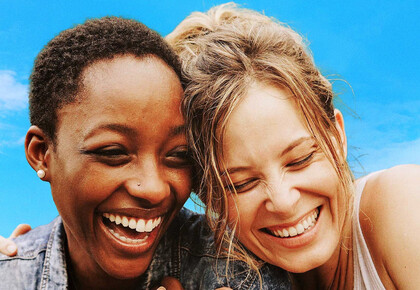 Zwei lachende Frauen mit dem Titel "A World Together"