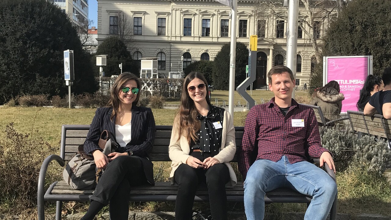 Studierende auf einer Bank während einer Exkursion nach Graz