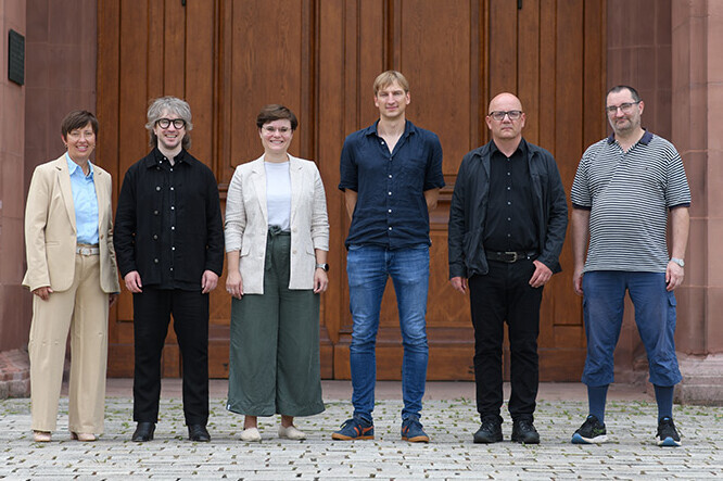 Das Team des Lehrstuhls Theoretische Philosophie steht vor dem Eingang zum Rittersaal des Mannheimer Schlosses.
