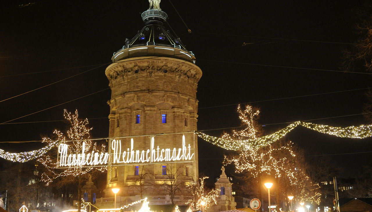 Der Mannheimer Weihnachtsmarkt am Wasserturm im Dunkeln.