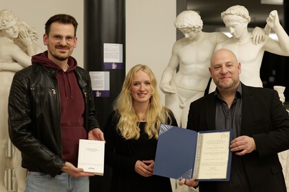 (Von links nach rechts): Jonas Brosig, Preisträgerin Marissa Kark und David Brechbilder bei der Übergabe des Andreas-Lamey-Preises im Antikensaal der Universität Mannheim. 
