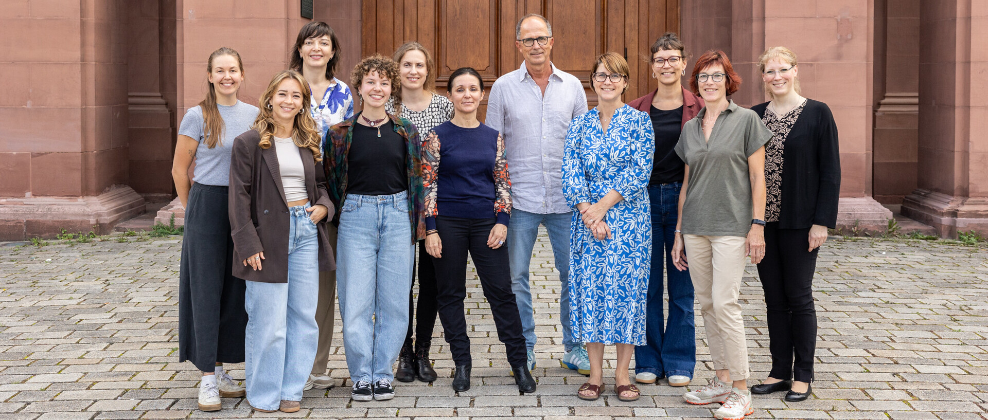 Das Team der Abteilung Sprach- und Medienwissenschaft bestehend aus 11 Personen vor dem Schloss in Mannheim.aus