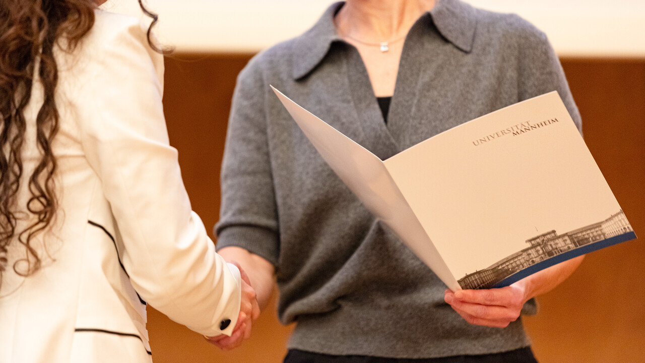 Bild von der Absolvierendenfeier 2024. Zu sehen ist die Übergabe eines Schmuckdiploms an eine Absolventin.