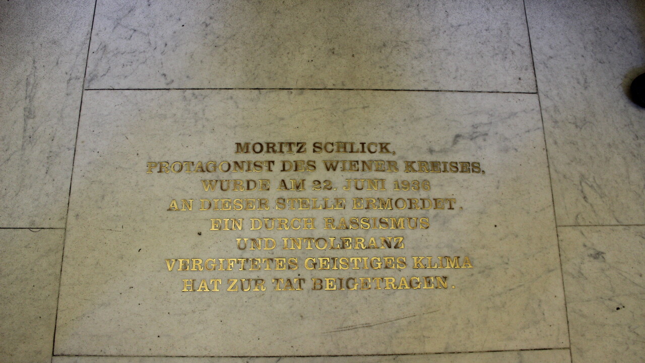 Gedenkstein mit Aufschrift "Moritz Schlick, Protagonist des Wiener Kreises, wurde am 22. Juni 1936 an dieser Stelle ermordet. Ein durch Rassismus und Intoleranz vergiftetes geistiges Klima hat zur Tat beigetragen."