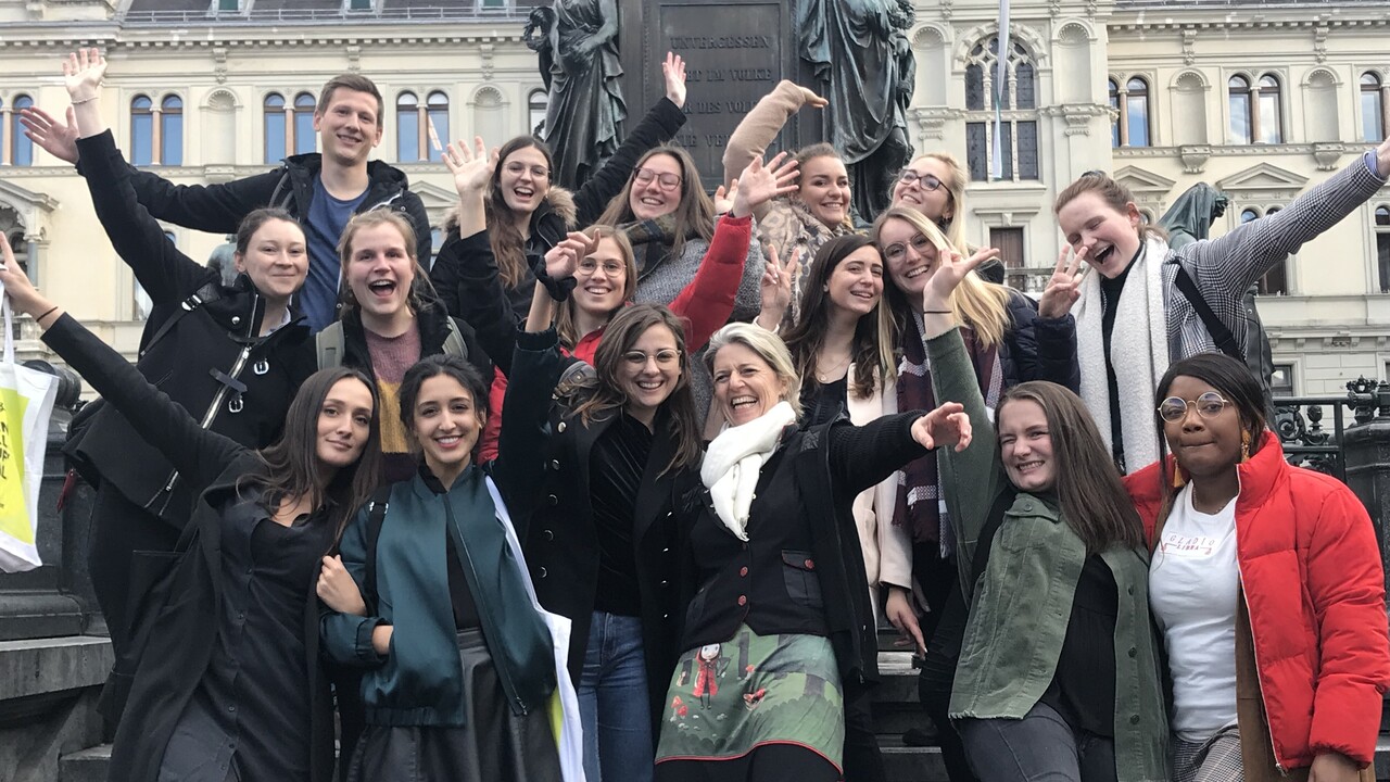 Gruppe von Studierenden vor einem Brunnen während einer Exkursion nach Graz