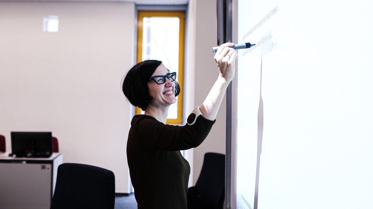 Dozentin schreibt auf das Whiteboard