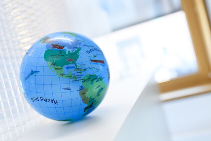 Eine Weltkugel liegt auf einem weißen Tisch