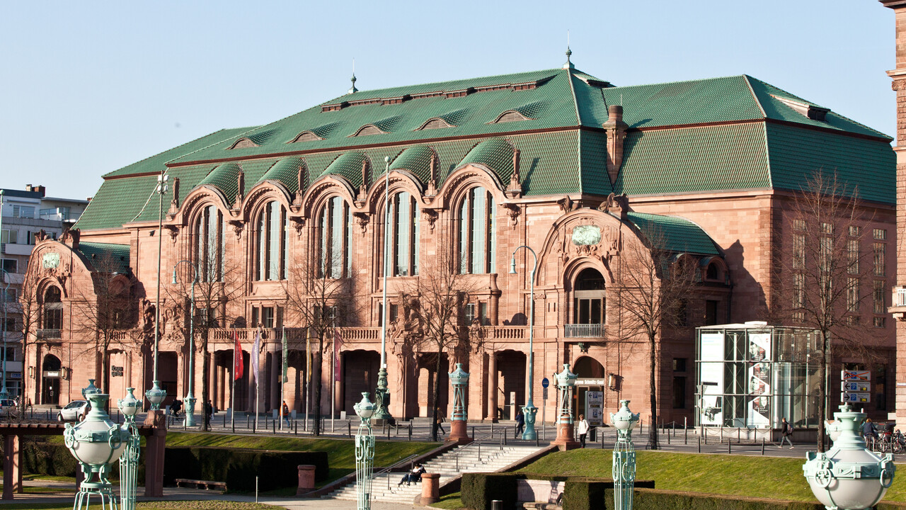 Ein großes, helles Gebäude mit grünem Dach.