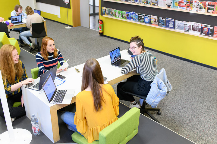 Vier Studentinnen mit Laptop am Tisch im Learningcenter.